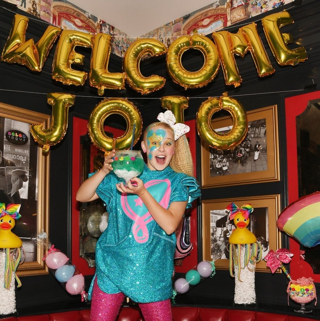 JoJo Siwa poses with non-alcoholic ocean blue goblet and JoJo themed decorations.