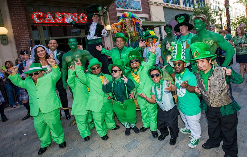 Gathered at the entrance of O’Sheas Casino, Brian “Lucky” Thomas, Joe Greene and Jennifer Michaelson, a troop of leprechauns, stilt walkers, balloon artists, green hunks and bag pipers, kicked-off O’Sheas St. Patty’s Day Block Party.
