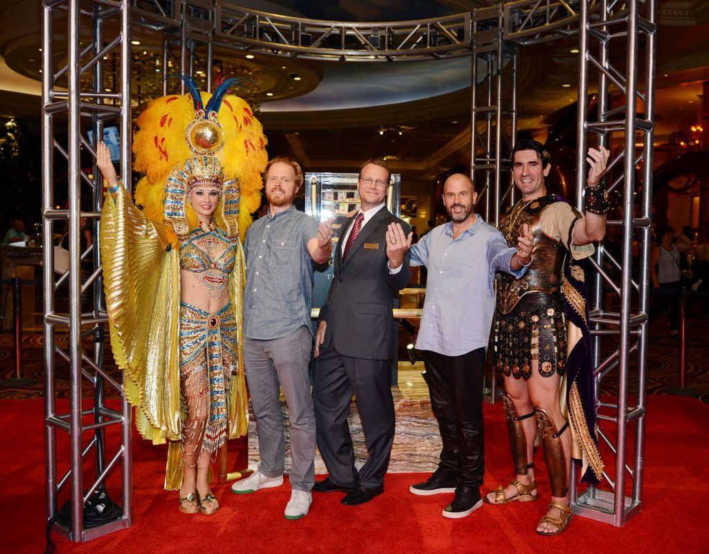From left to right: co-author Nils Johnson-Shelton, Caesars Palace Vice President of Marketing Eric Proffitt and co-author James Frey pose with Caesar and Cleopatra in front of the gold display.