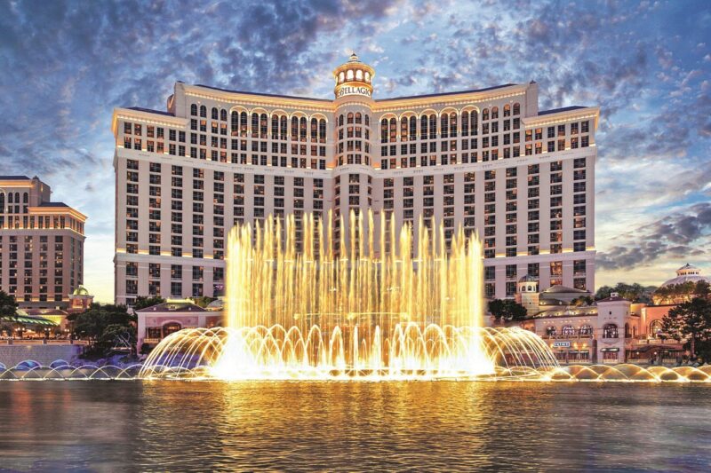 The Fountains of Bellagio performing at dusk with the resort illuminated in the background.